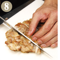 皮面を下にして、鶏モモ肉を切ります